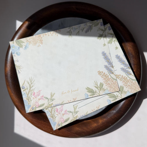 Floral-patterned envelopes on a wooden plate