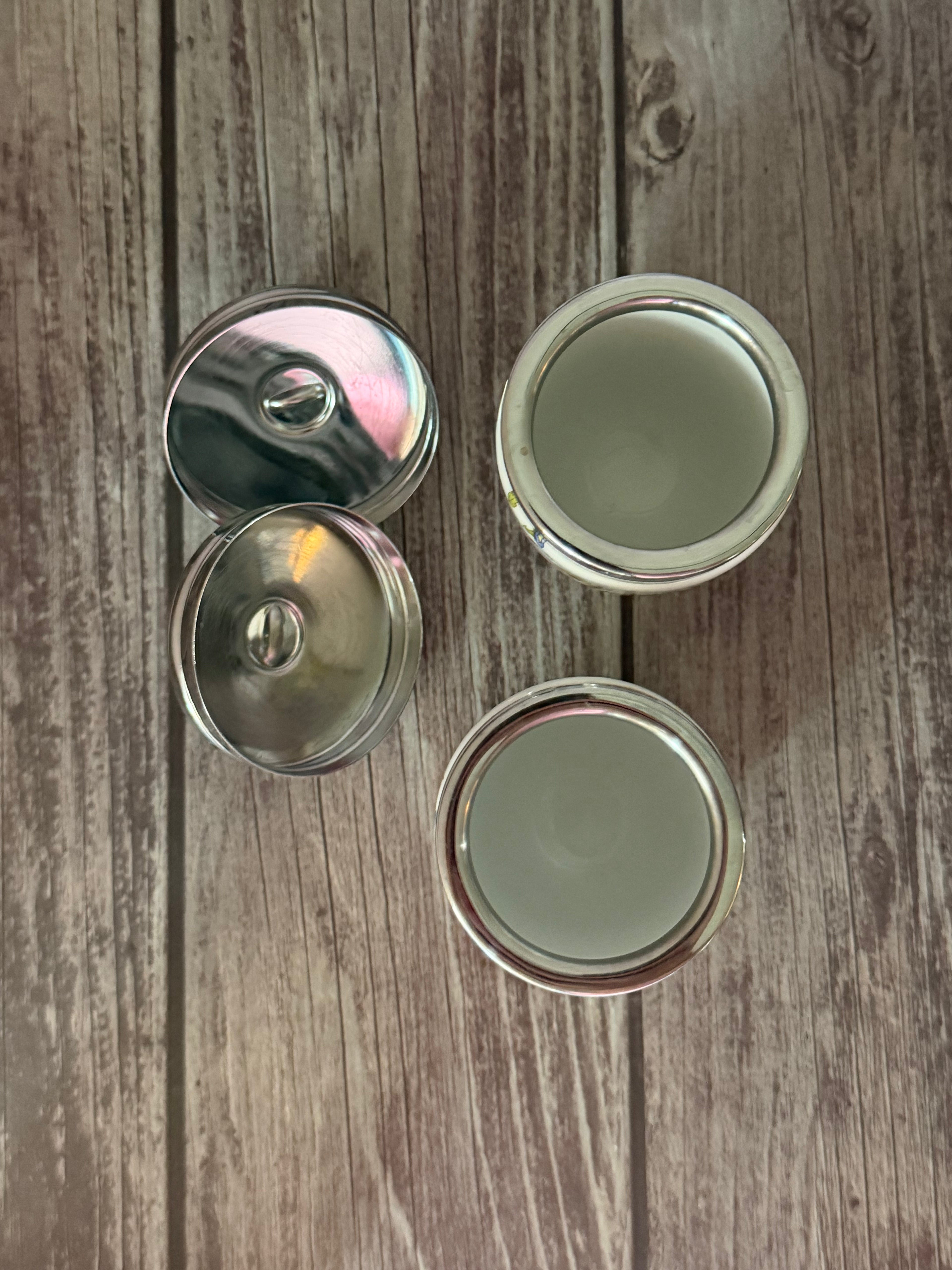 Four metallic bottle caps on a wooden surface