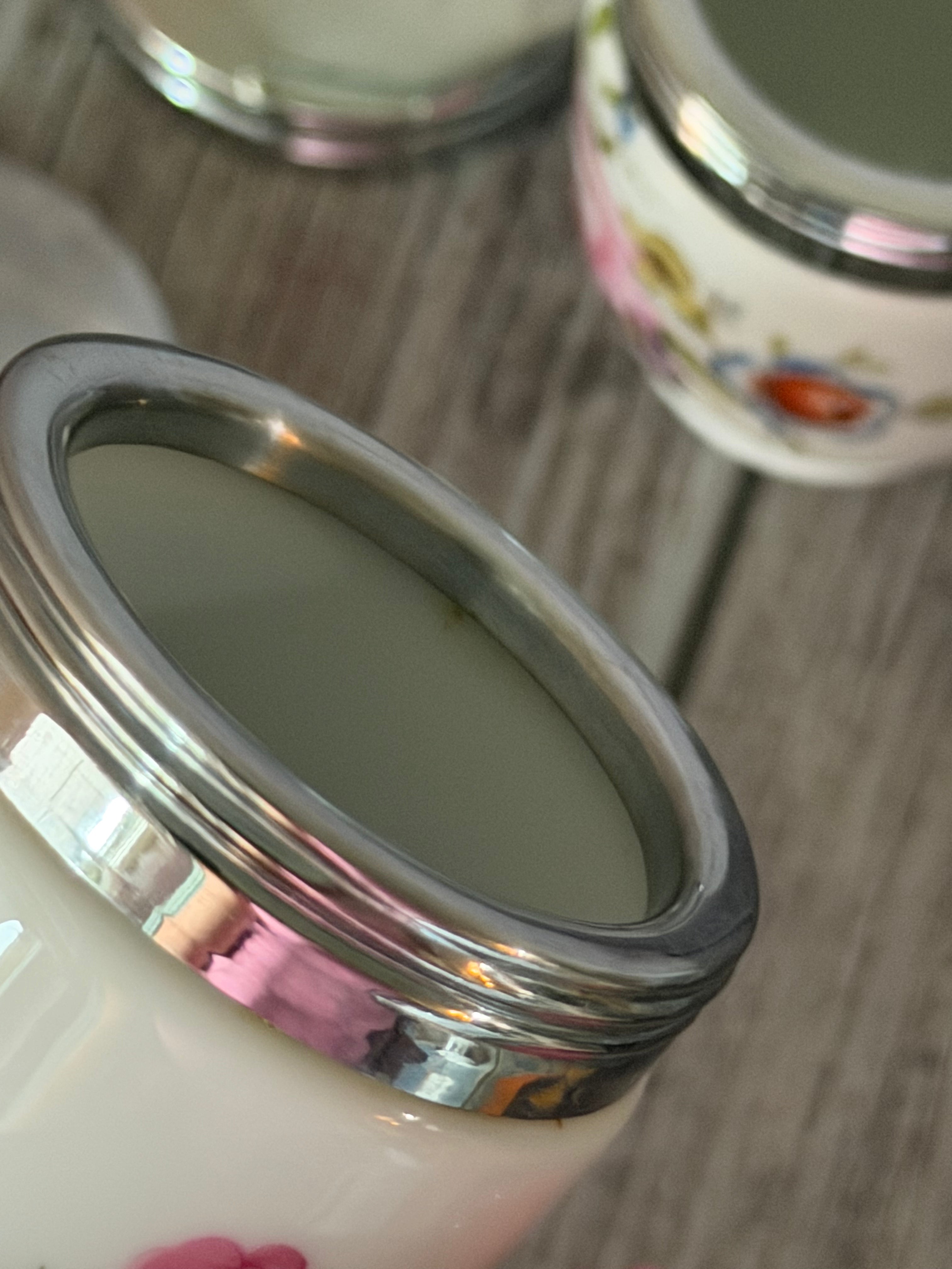 Close-up of a ceramic jar with a metal lid on a wooden surface
