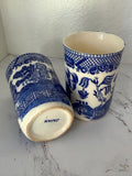 Two blue and white ceramic cups with intricate patterns on a marble surface.
